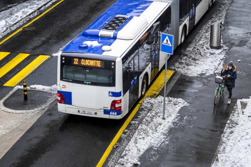 Une personne pousse son velo a cote d&#039;un bus des Transports publics de la region lausannoise lors de la presentation en conference de presse du plan climat de la ville de Lausanne le mercredi 13  ...