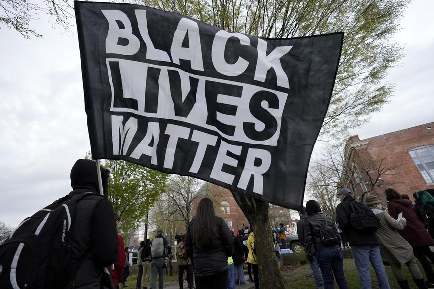 A demonstrator display a banner during a protest, Wednesday, April 21, 2021, in the Nubian Square neighborhood, of Boston, a day after a guilty verdict was announced at the trial of former Minneapolis ...