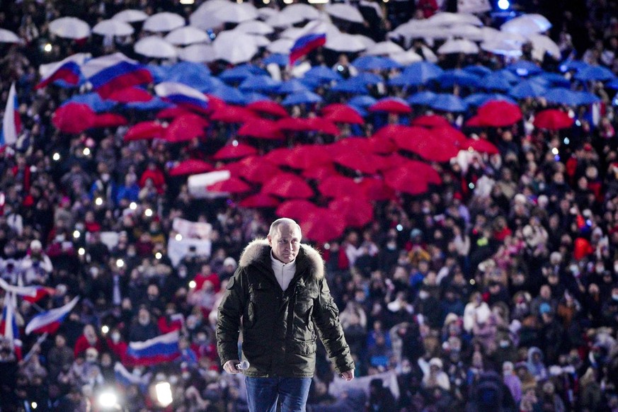 Russian President Vladimir Putin arrives to attend a concert marking the seventh anniversary of the referendum on the state status of Crimea and Sevastopol and its reunification with Russia, in Moscow ...