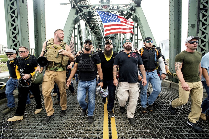 FILE - Members of the Proud Boys, including organizer Joe Biggs, third from right, march across the Hawthorne Bridge during an &quot;End Domestic Terrorism&quot; rally in Portland, Ore., on Saturday,  ...