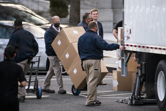 epa08938159 Workers move boxes onto a truck that were stacked on West Executive Avenue between the White House and the Eisenhower Executive Office Building in Washington, DC, USA, 14 January 2021. EPA ...