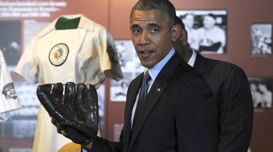 President Barack Obama holds Joe DiMaggio’s well-worn glove during a tour the Baseball Hall of Fame in Cooperstown, N.Y., Thursday, May 22, 2014. Obama visited the museum to highlight tourism and step ...