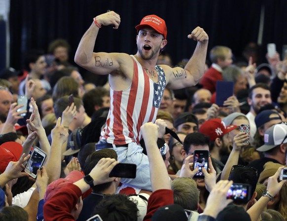 FILE - In this April 15, 2016, file photo, a Donald Trump supporter flexes his muscles with the words &quot;Build The Wall&quot; written on them as then-Republican Presidential candidate Donald Trump  ...