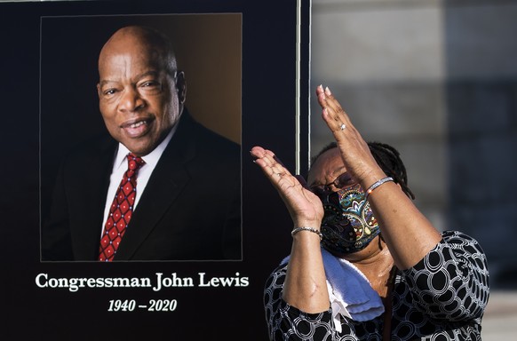 Jaquenette Ferguson from Oxon Hill, Md., gestures as she gets her picture taken beside a portrait of the late Rep. John Lewis, D-Ga., near the East Front Steps of the U.S. the Capitol, Tuesday, July 2 ...