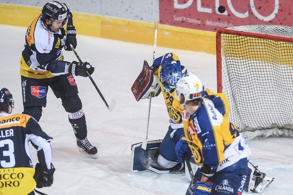 Ambri&#039;s player Brian Flynn, left, fights for the puck with Davos&#039; goalkeeper Sandro Aeschlimann, right, during the match of National League A Swiss Championship between HC Ambri Piotta and H ...