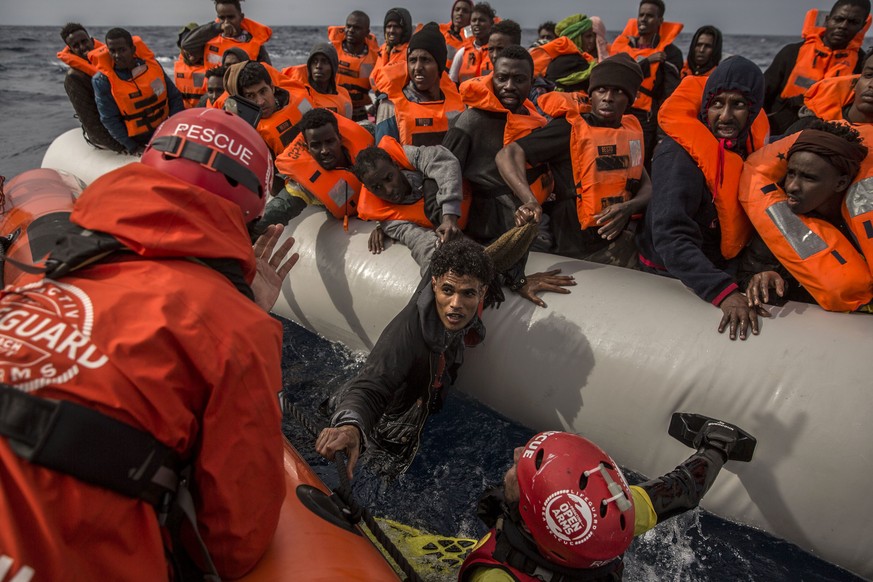 FILE - In this Sunday, Feb 18, 2018 file photo, refugees and migrants are rescued by aid workers of the Spanish NGO Proactiva Open Arms, after leaving Libya trying to reach European soil aboard an ove ...