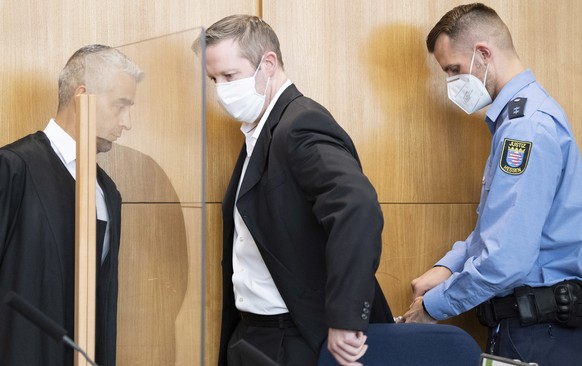 epa08568455 A judical officer (R) opens the handcuffs of Stephan Ernst (C), who is accused of the murder of the politician Walter Luebcke, as his lawyer Mustafa Kaplan looks on after arriving for a he ...