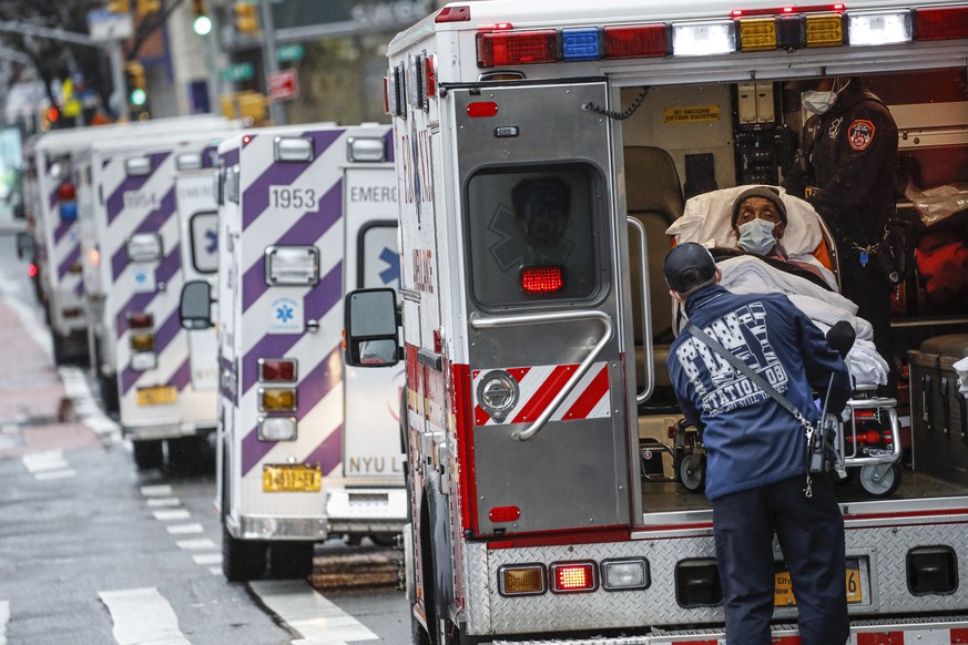 FILE - In this April 13, 2020, file photo, a patient arrives in an ambulance cared for by medical workers wearing personal protective equipment due to COVID-19 concerns outside NYU Langone Medical Cen ...