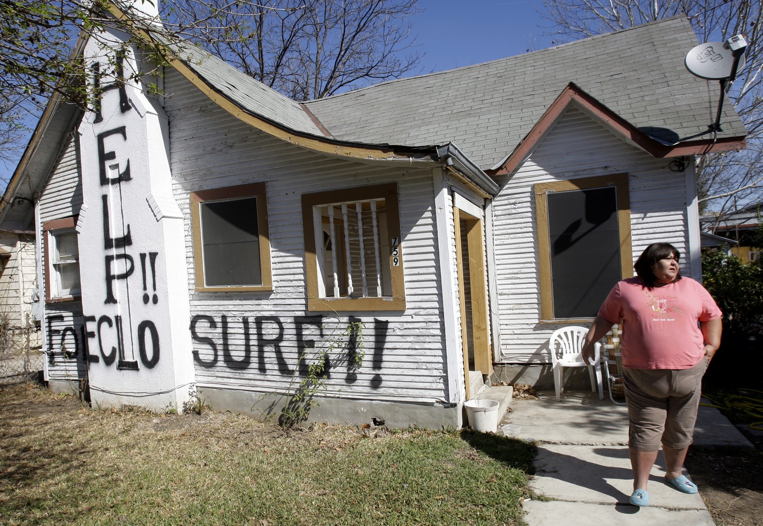 FILE - In this Feb. 23, 2009 file photo, Mary Ann Herrera stands outside her home in San Antonio, Monday, Feb. 23, 2009. Under the threat of foreclosure, Herrara&#039;s brother painted the words &quot ...