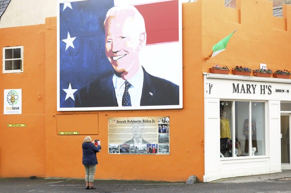 A woman takes a picture of a mural of US Presidential candidate Joe Biden in Ballina, west of Ireland, Wednesday, Nov. 4, 2020. Ballina is the ancestral home of US Presidential candidate Joe Biden. (A ...