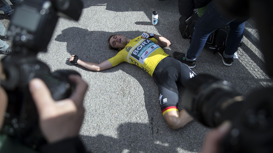 Team Bora Hansgrohe&#039;s Maximilian Schachmann, of Germany, collapses on the floor after crossing the finish line to win the yellow leaders jersey during the seventh and final stage of the Paris Nic ...