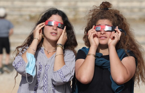 epa08499506 People use special protective glasses to observe a partial solar eclipse in Jerusalem, Israel, 21 June 2020. The partial solar eclipse ? which occurs when a portion of the Earth is engulfe ...