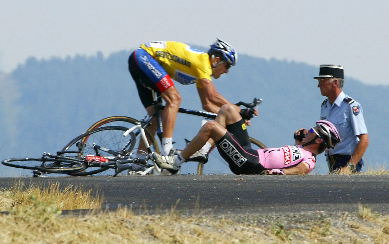 US Lance Armstrong (US Postal/USA) avoids Spaniard Joseba Beloki (ONCE/Spa) who fell down at the end of the ninth stage of the 90th Tour de France cycling race between Bourg d &amp;acute;Oisans and Ga ...