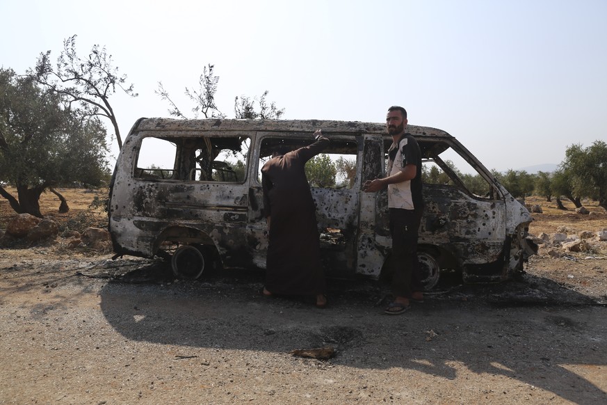 People look at a destroyed van near the village of Barisha, in Idlib province, Syria, Sunday, Oct. 27, 2019, after an operation by the U.S. military which targeted Abu Bakr al-Baghdadi, the shadowy le ...