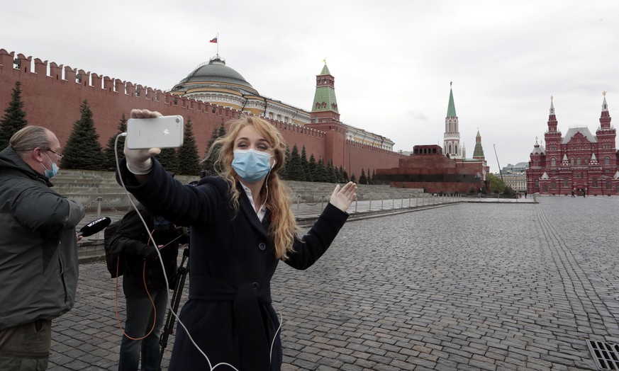 epa08411300 Russian journalist produces a live report from Red square during Victory Day air force parade marking 75-th anniversary of the victory in the World War II in Moscow, Russia, 09 May 2020. T ...