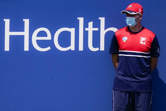 FILE - In this Saturday, Aug. 22, 2020, file photo, a ball boy stands at attention while wearing a protective mask during the Western &amp; Southern Open tennis tournament at Flushing Meadows in New Y ...