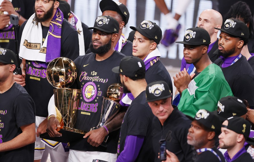 epa08736885 Los Angeles Lakers forward LeBron James (C-L) holds the MVP trophy and the Larry O&#039;Bren trophy after defeating the Miami Heat to win the 2020 NBA Finals at the ESPN Wide World of Spor ...