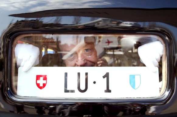 Stolz befestigt der Objektunterhalter des Verkehrshauses Luzern, Hans-Peter Oehen, das kurz zuvor am Freitag, 14. Maerz 2003, von der Luzerner Regierung erhaltene Autonummernschid LU-1 an die Hecksche ...