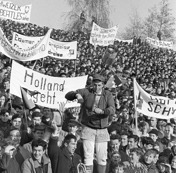 Zuschauer halten waehrend des WM-Ausscheidungsspiels zwischen der Schweiz und der Niederlande am 14. November 1965 im Wankdorfstadion in Bern Transparente hoch und spielen auf Trompeten und anderen In ...