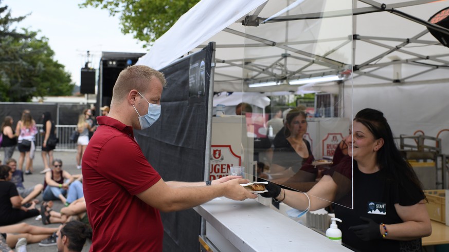 A man wearing a protective mask orders food, at the ?Swiss Mountain Roadshow?, during the coronavirus disease (COVID-19) outbreak, in Steffisburg, Switzerland, Thursday, July 30, 2020. The Swiss Mount ...