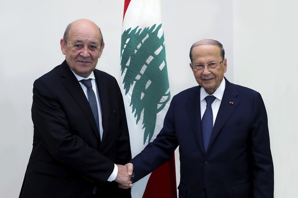 In this photo released by Lebanon&#039;s government, Lebanese president Michel Aoun, left, shakes hands with French Foreign Minister Jean-Yves Le Drian, at the Presidential Palace, in Baabda, east of  ...