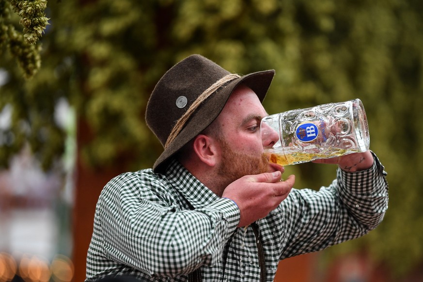 epa07859023 A visitor downs a mug of beer at the Hofbraeu tent during the opening day of the 186th Oktoberfest beer festival on the Theresienwiese in Munich, Germany, 21 September 2019. The Munich Bee ...