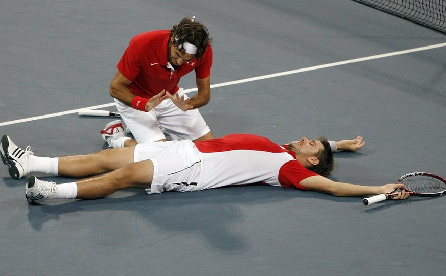 Roger Federer, left, and Stanislas Wawrinka of Switzerland react after winning their match against Bob Bryan and Mike Bryan during the semi final of the men&#039;s double tennis at the Beijing 2008 Ol ...