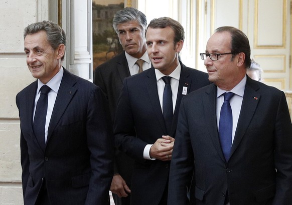 France&#039;s President Emmanuel Macron, center, former Presidents Nicolas Sarkozy, left, and Francois Hollande arrive at a ceremony for the French Olympic delegation at the Elysee Palace, in Paris, F ...