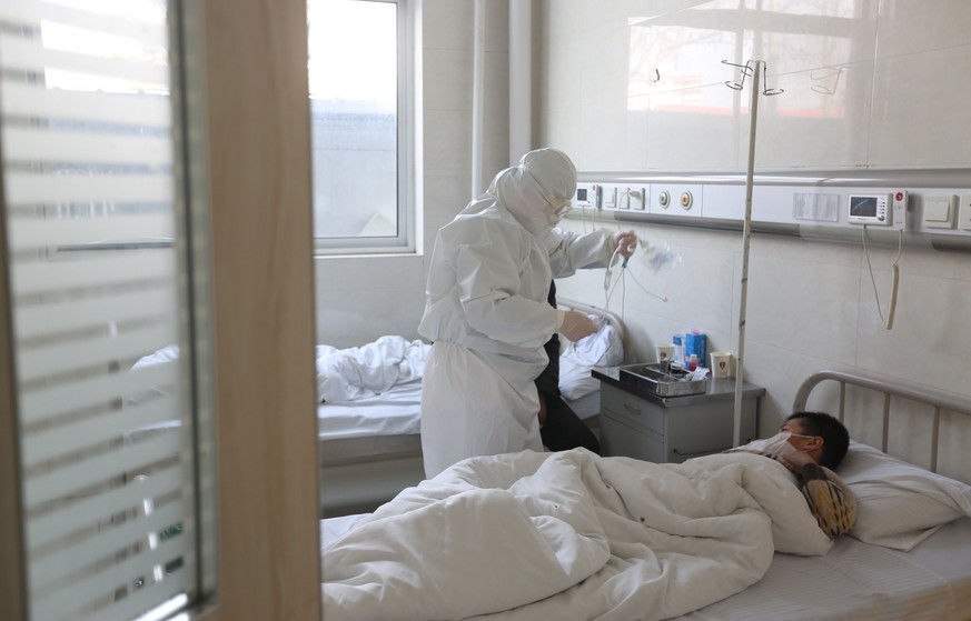 epa08212643 A doctor takes care of a fever patient in an isolation ward in a hospital in Yinan County, in east China&#039;s Shandong province, 12 February 2020. The disease caused by the new coronavir ...