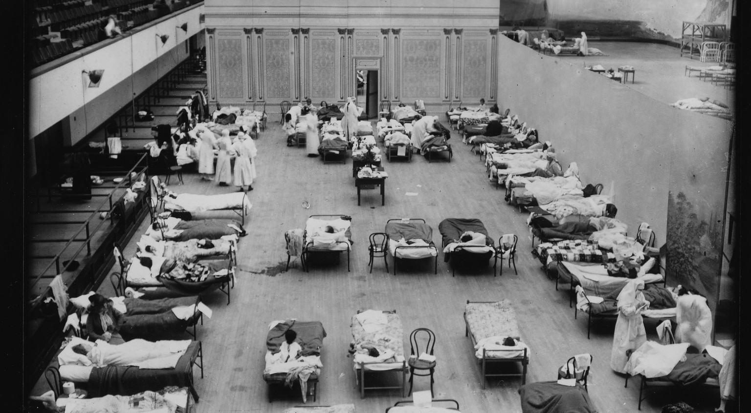 OAKLAND, CALIFORNIA - CIRCA OCTOBER 1918 - During the Spanish Flu pandemic, the Oakland Civic Auditorium was converted into a makeshift infirmary. This photo shows the women&#039;s ward. Stage scenery ...