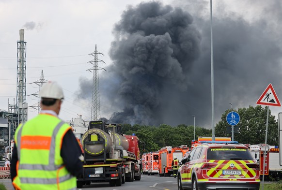 27.07.2021, Nordrhein-Westfalen, Leverkusen: Einsatzfahrzeuge der Feuerwehr stehen unweit einer Zufahrt zum Chempark