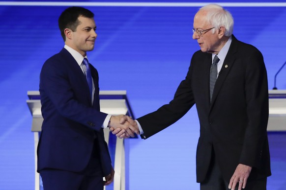 Democratic presidential candidates former South Bend Mayor Pete Buttigieg and Sen. Bernie Sanders, I-Vt., shake hands on stage Friday, Feb. 7, 2020, before the start of a Democratic presidential prima ...