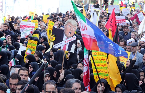 epa07140573 Iranians hold a placard showing an image of US President Donald J. Trump during an anti-US demonstration marking the 39th anniversary of US Embassy takeover, in front of the former US emba ...
