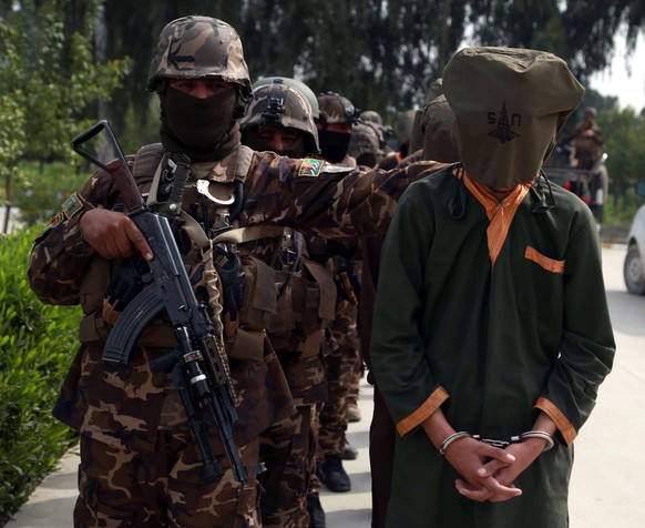 epa08283225 Afghan security officials show a group of suspected militants allegedly accused of planning attacks on government and security forces after their arrest from different areas, in Jalalabad, ...