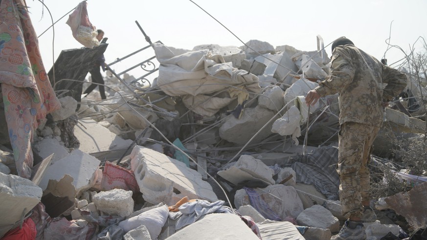 epa07955663 People walk amound the rubble of destroyed buildings at the site that was hit by helicopter gunfire which reportedly killed nine people, including Abu Baker al-Baghdadi, the leader of IS o ...