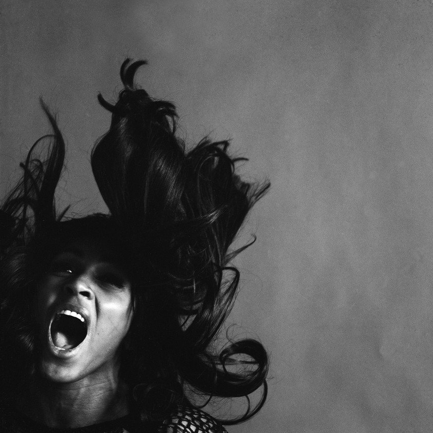 Studio portrait of American rock singer Tina Turner, wearing a dark crocheted mini-dress, singing while her long dark hair flies around her face, New York, New York, November 25, 1969. (Photo by Jack  ...