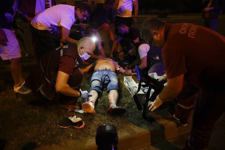 Paramedics treat a wounded person after clashes with police man in Minsk, Belarus, Sunday, Aug. 9, 2020. Police and protesters clashed in Belarus&#039; capital and the major city of Brest on Sunday af ...