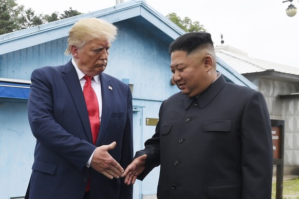 FILE - In this June 30, 2019, file photo, North Korean leader Kim Jong Un, right, and U.S. President Donald Trump prepare to shake hands at the border village of Panmunjom in the Demilitarized Zone, S ...