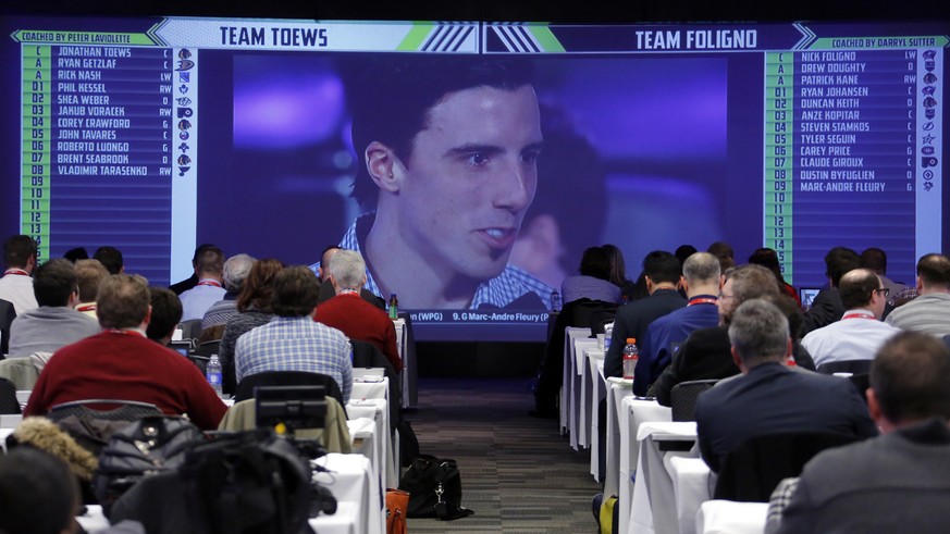 Members of the media watch on a television in a hotel ballroom as Pittsburgh Penguins goalie Marc-Andre Fleury is chosen by Team Toews during the NHL Fantasy Draft in Columbus, Ohio, Friday, Jan. 23,  ...
