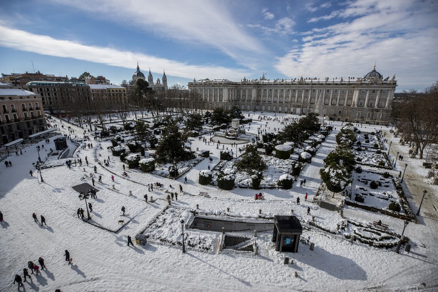A view of Oriente square covered with snow with the Royal Palace in front in downtown Madrid, Spain, Sunday, Jan. 10, 2021. A large part of central Spain including the capital of Madrid are slowly cle ...