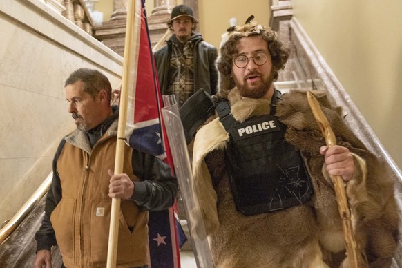 FILE - In this Jan. 6, 2021 file photo, supporters of President Donald Trump, including Aaron Mostofsky, right, who is identified in his arrest warrant, walk down the stairs outside the Senate Chamber ...