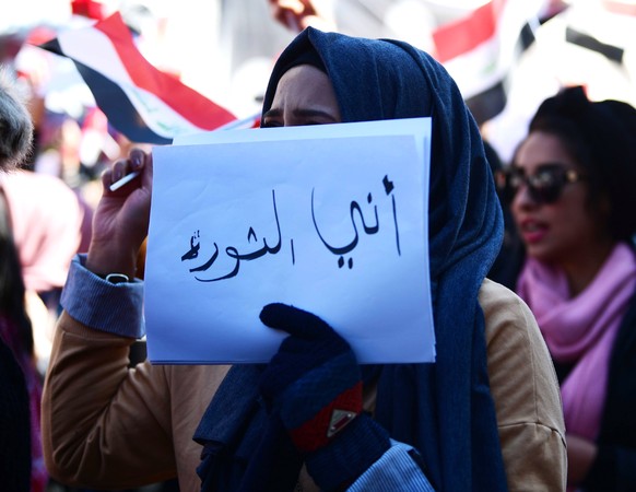 epa08215011 An Iraqi woman carries a placard reading in Arabic &#039;I am the revolution&#039; during a demonstration at the Al-Tahrir square in central Baghdad, Iraq, 13 February 2020. Hundreds of Ir ...