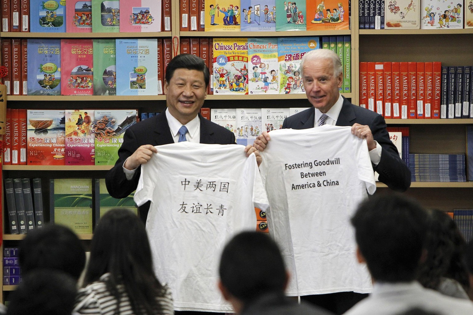 FILE - In this Friday, Feb. 17, 2012 file photo, Chinese Vice President Xi Jinping and U.S. Vice President Joe Biden hold T-shirts given to them by students during their visit to the International Stu ...