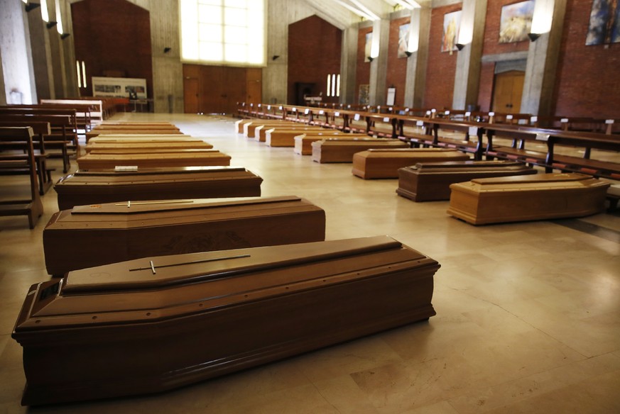 FILE - In this March 26, 2020 file photo, coffins are lined up on the floor in the San Giuseppe church in Seriate, one of the areas worst hit by coronavirus, near Bergamo, Italy, waiting to be taken t ...