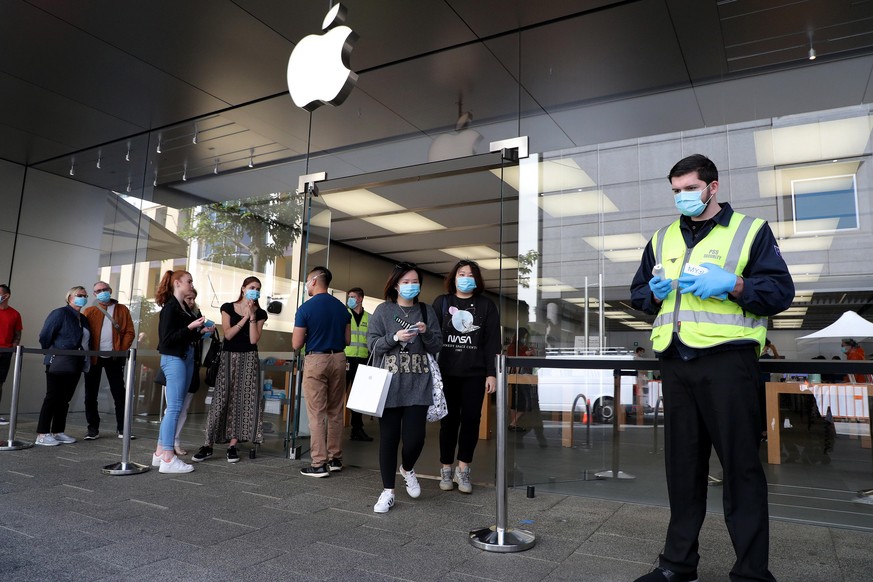 epa08428876 Customers are given face maskes to wear before entring an Apple Store in Perth, Australia, 18 May 2020. People are being encouraged to return to work in Western Australia, 18 May with cafe ...