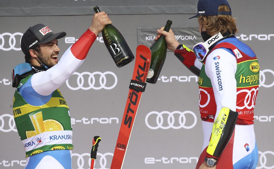 Second placed Loic Meillard, left, and winner Marco Odermatt, both of Switzerland, celebrate on the podium of an alpine ski, World Cup men&#039;s giant slalom in Kranjska Gora, Slovenia, Saturday, Mar ...