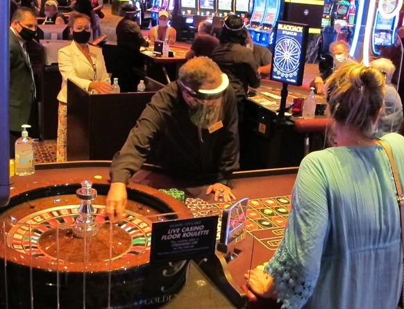 Wearing a face shield to guard against the coronavirus, a dealer conducts a roulette game at the Golden Nugget casino in Atlantic City, N.J. on July 2, 2020. The U.S. gambling industry was a big winne ...