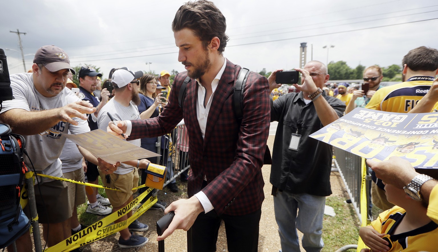 Nashville Predators defenseman Roman Josi, of Switzerland, signs autographs as he arrives at the airport Saturday, May 27, 2017, in Nashville, Tenn., for their flight to Pittsburgh for the NHL hockey  ...
