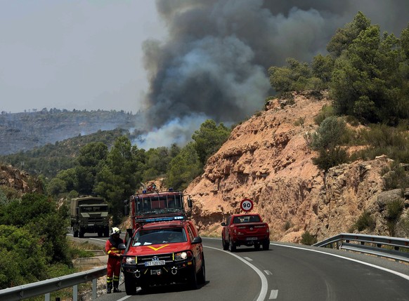 epa07677411 Emergency vehicles are seen near a forest fire in La Torre de l&#039;Espanyol in Tarragona, Spain, 27 June 2019. Fire emergency teams work to control the flames that have already burnt 4,0 ...