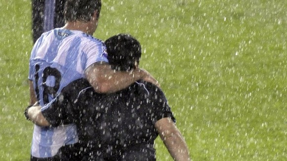 Under pouring rain, Argentina&#039;s Martin Palermo, left, and Argentina&#039;s coach Diego Maradona leave the field at the end of a 2010 World Cup qualifying soccer match against Peru in Buenos Aires ...